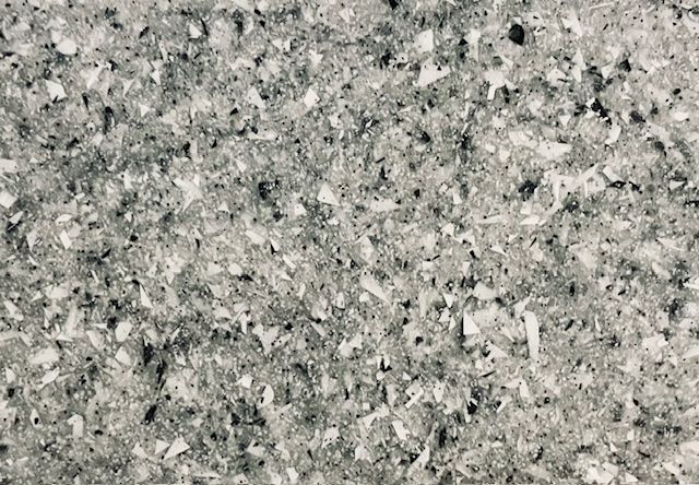 A close up of a gray and white granite counter top.