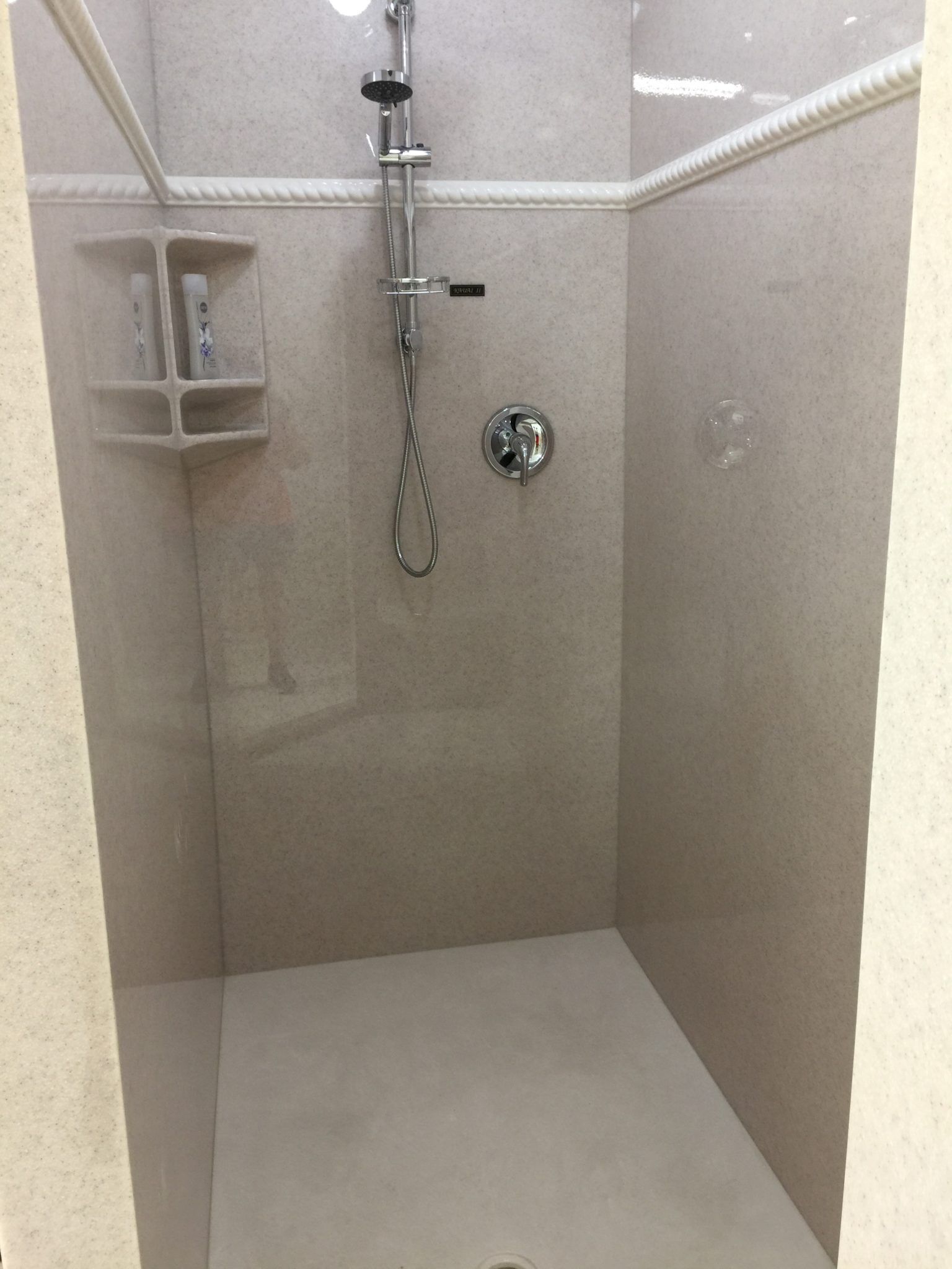 A shower with a shower head hanging from the ceiling