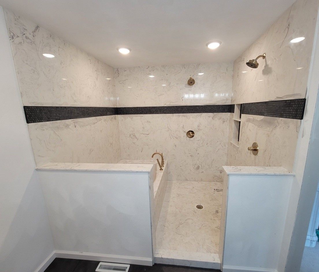 A bathroom with a walk in shower , tub , sink and mirror.