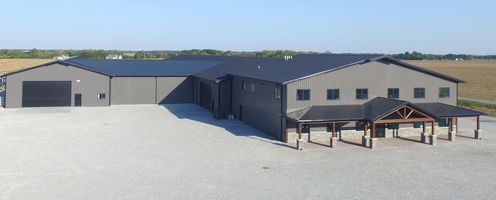 An aerial view of a large metal building with a black roof.