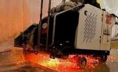 A man wearing a hard hat is working on a machine in a room.