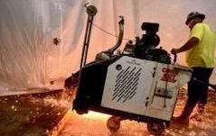 A large warehouse with a shiny concrete floor and lots of lights.