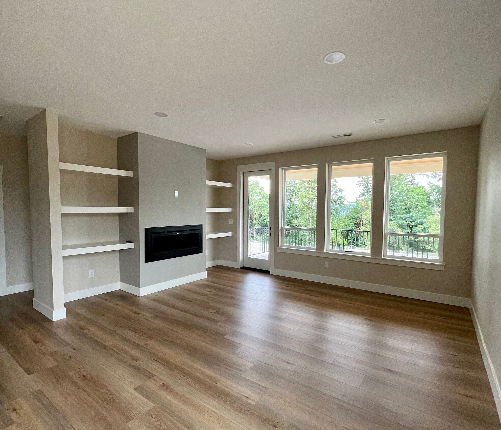 An empty living room with hardwood floors and a fireplace