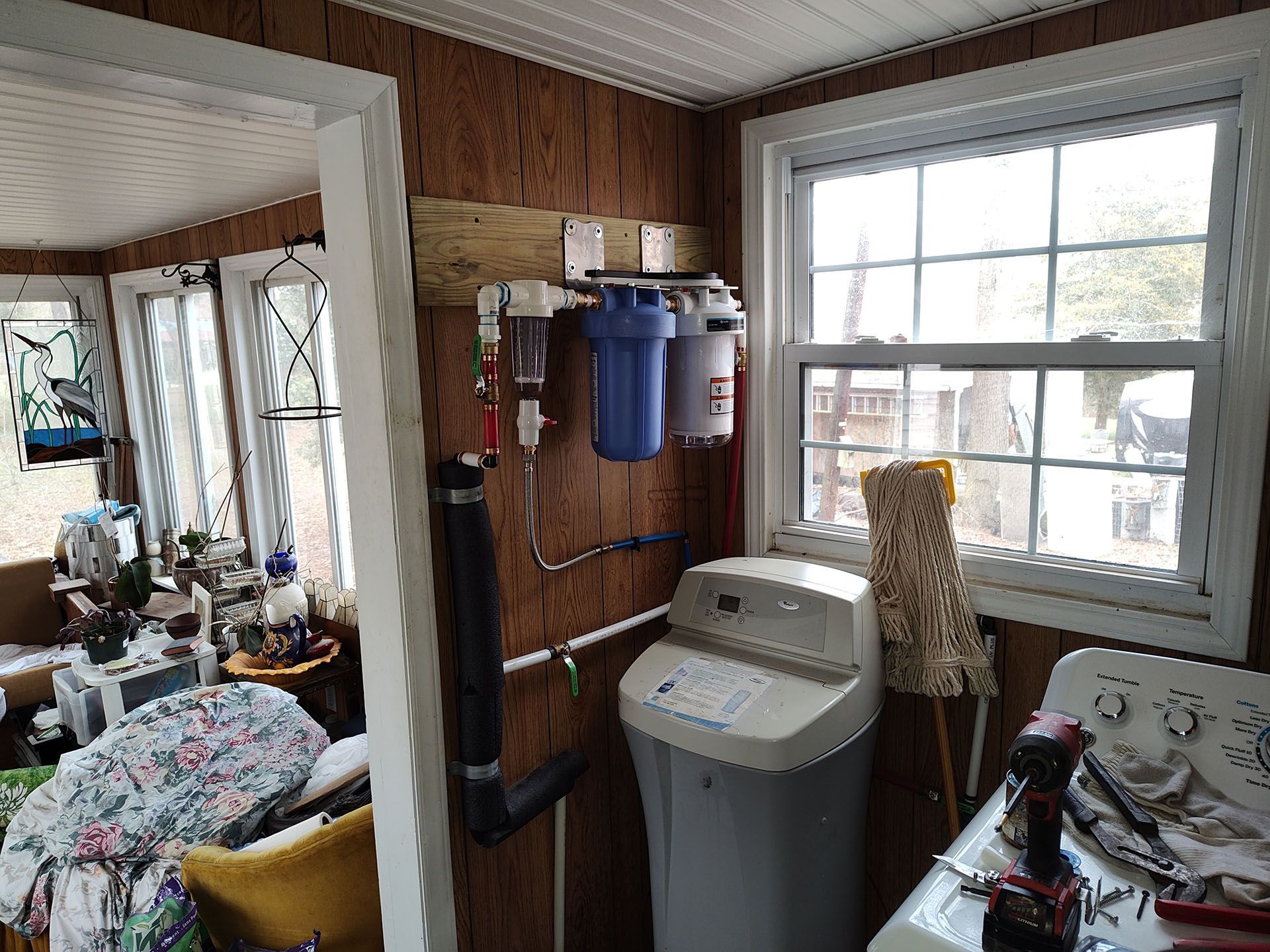 Water filtration system, softener, and window in a utility room.