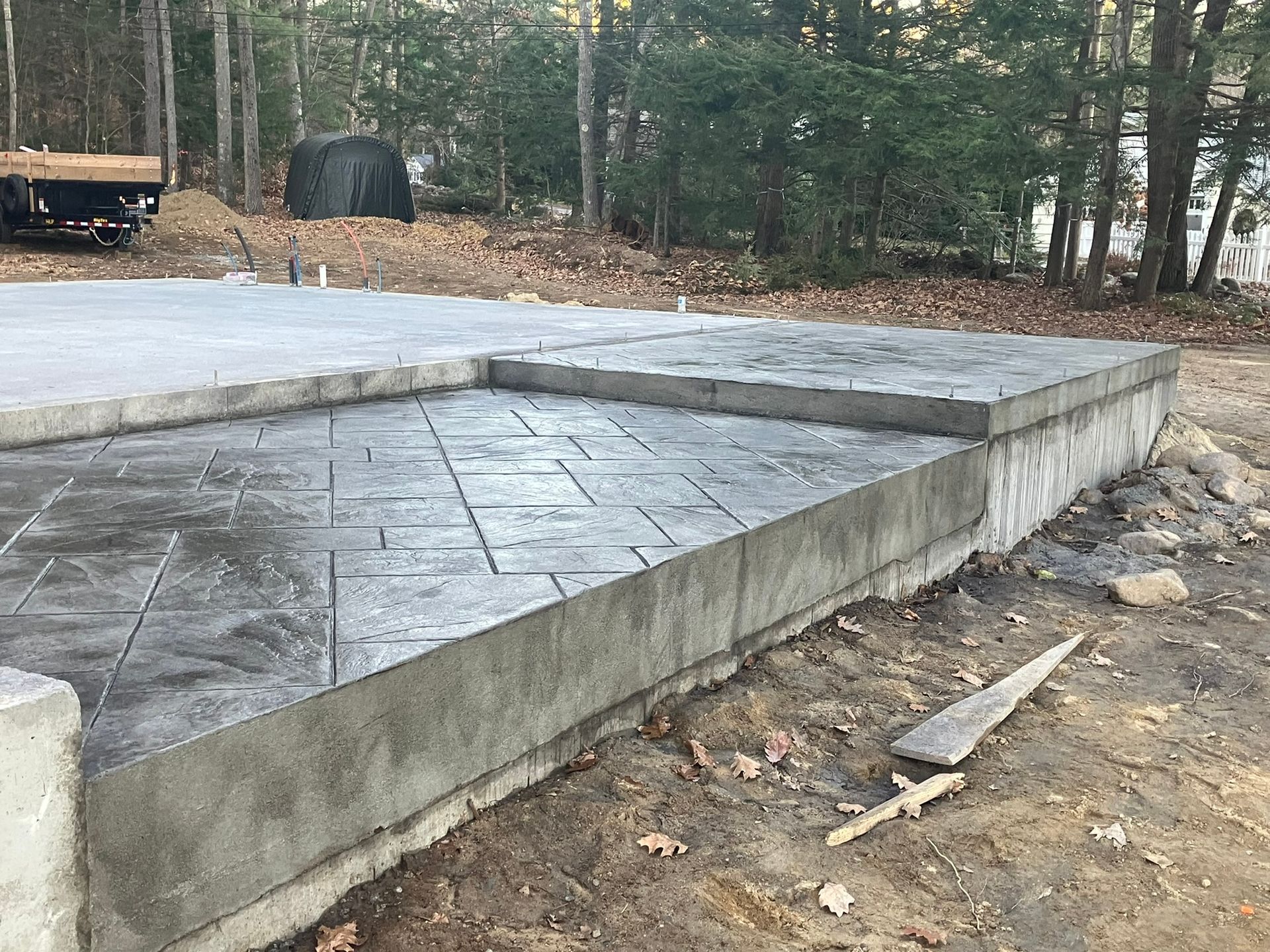 Newly poured concrete foundation with textured patio, outdoors.