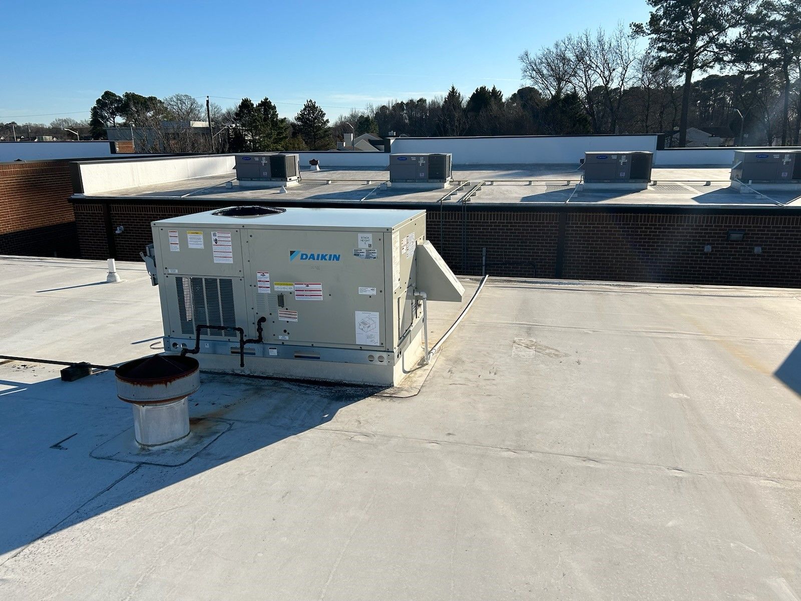 A panasonic air conditioner is sitting on top of a roof.
