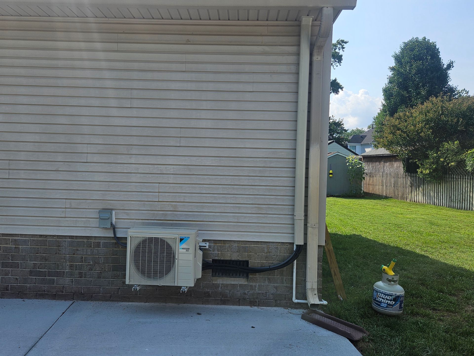 Air conditioning system outside on the side of the house.