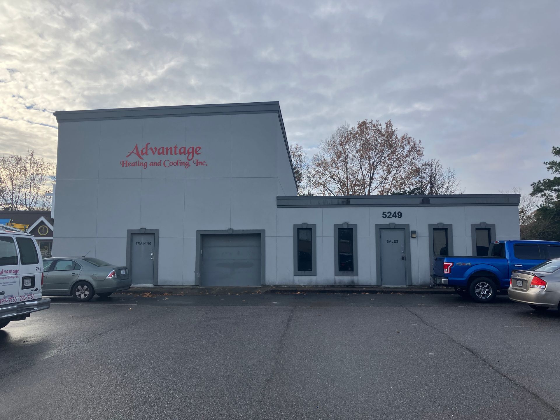 A white building with a red sign that says advantage