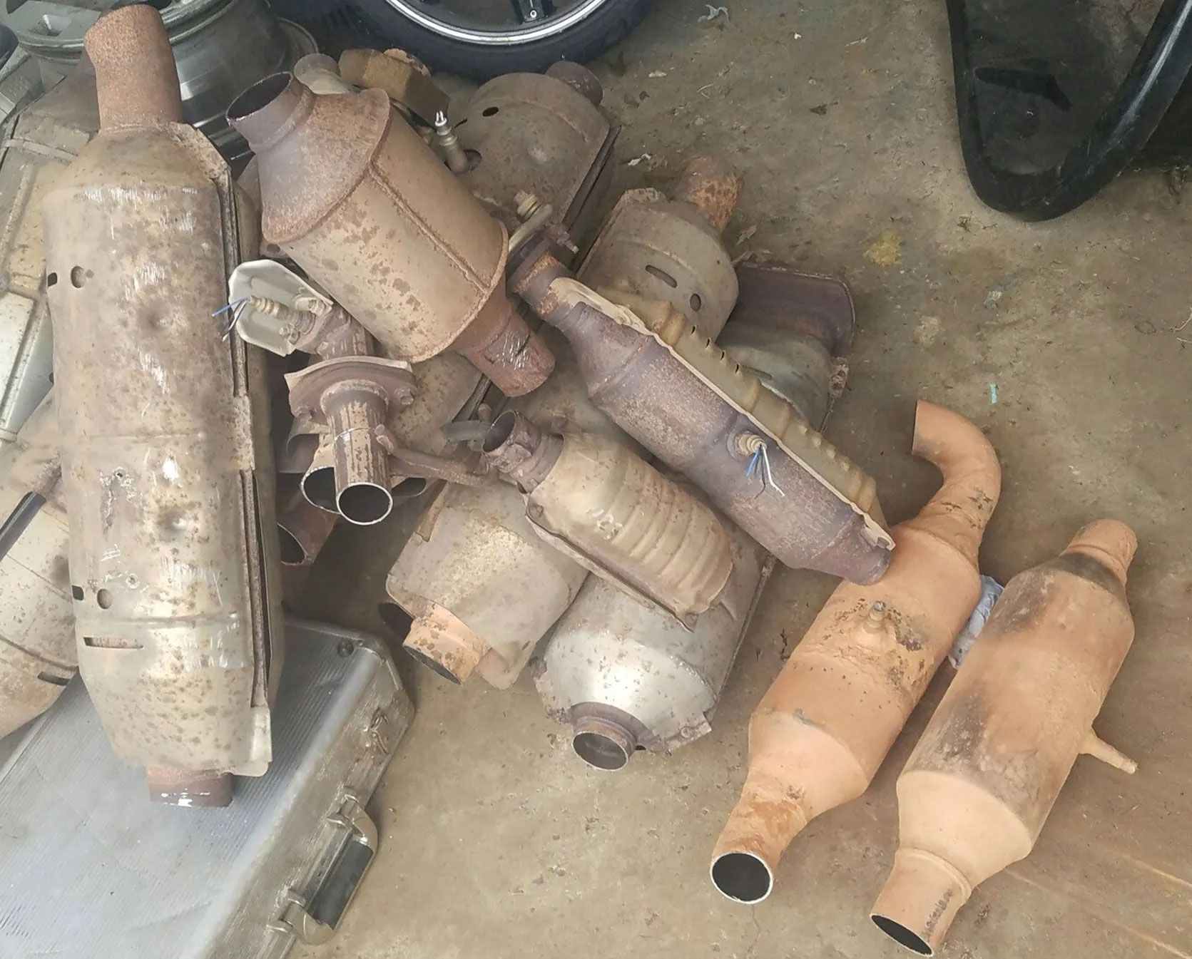Pile of used, rusty catalytic converters, likely for scrap