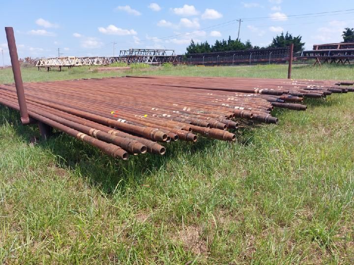 Rusty metal pipes on green grass, outdoors