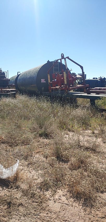 A cylindrical tank sits in a field