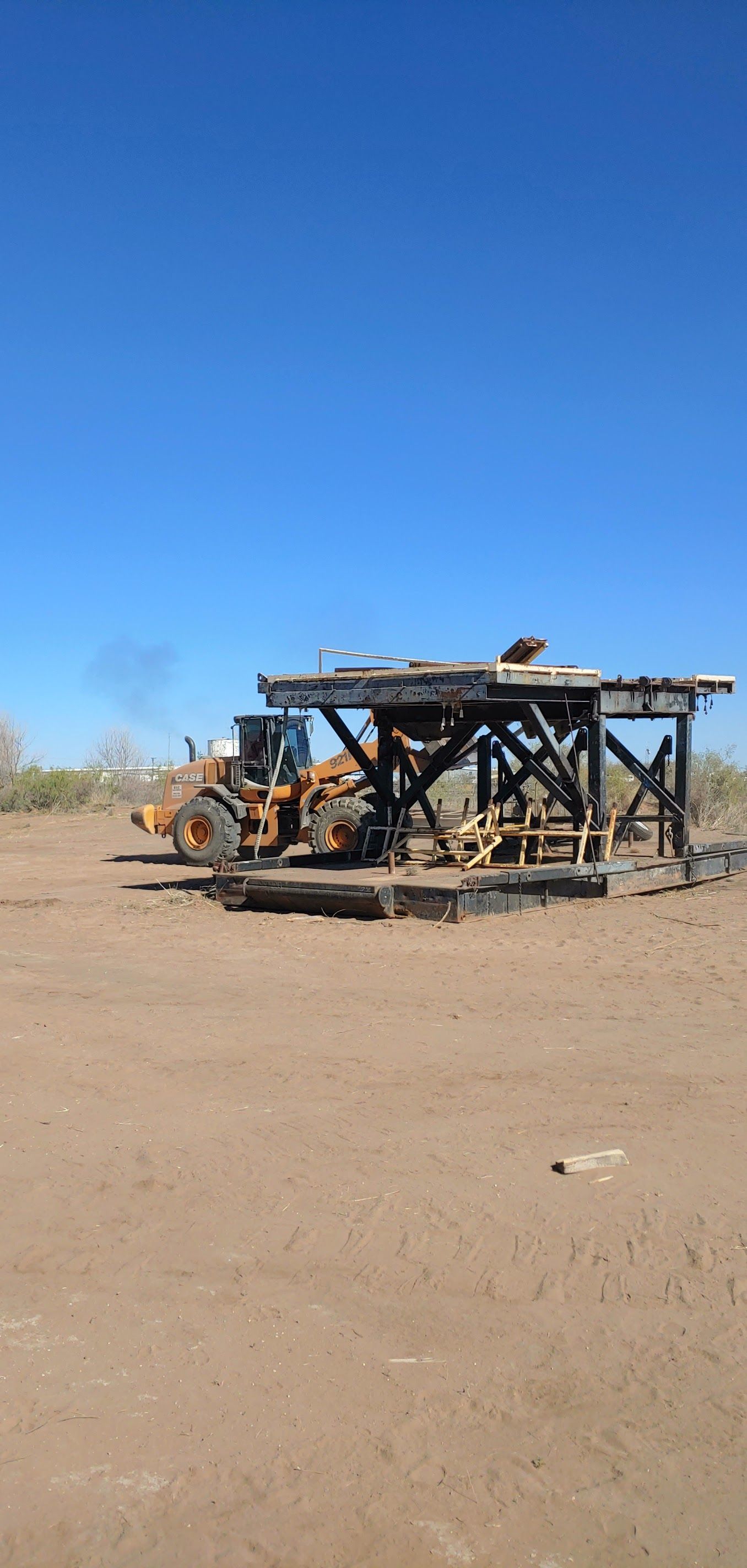 An orange loader next to a metal structure