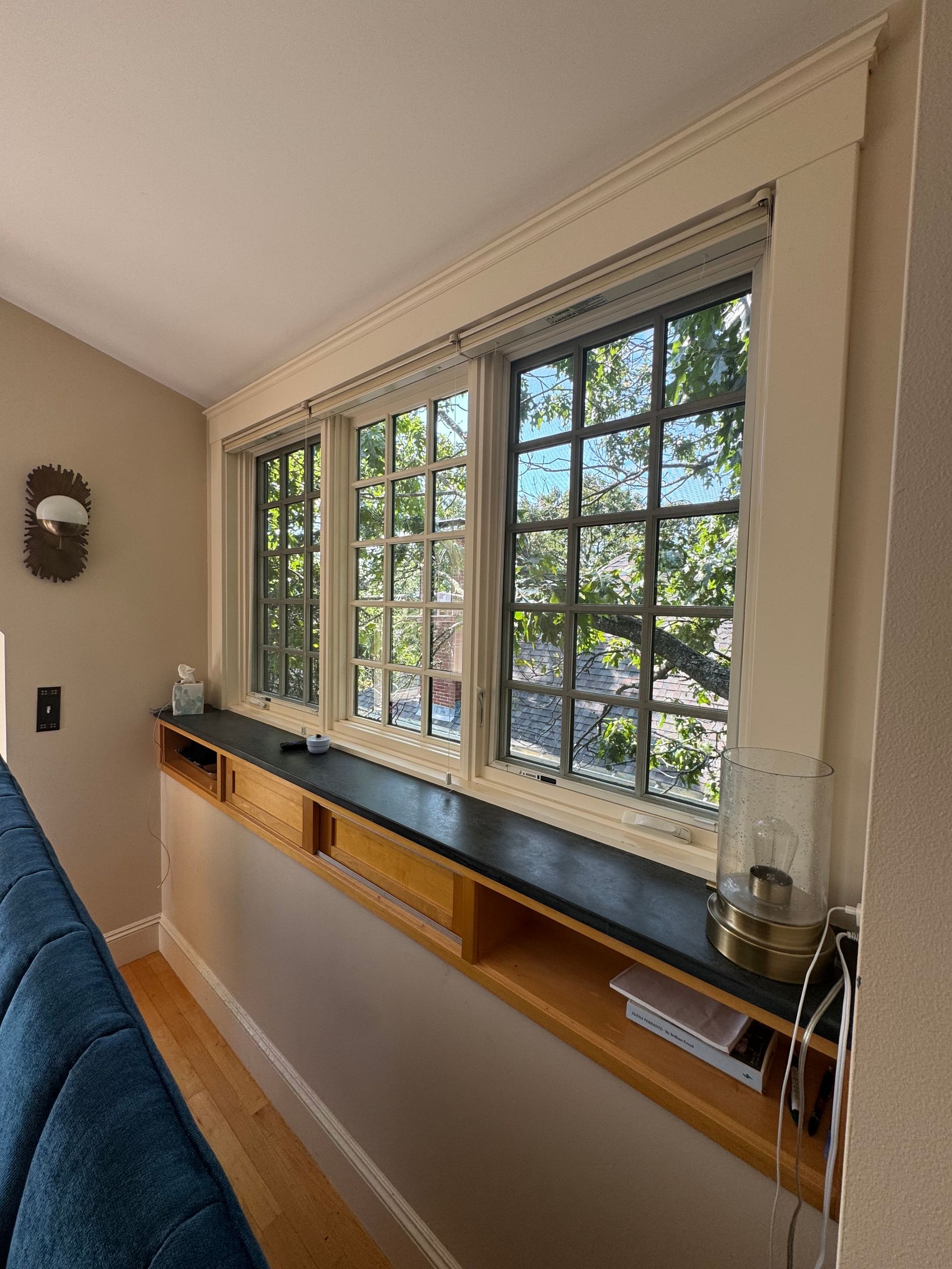 A living room with a blue couch and a large window.