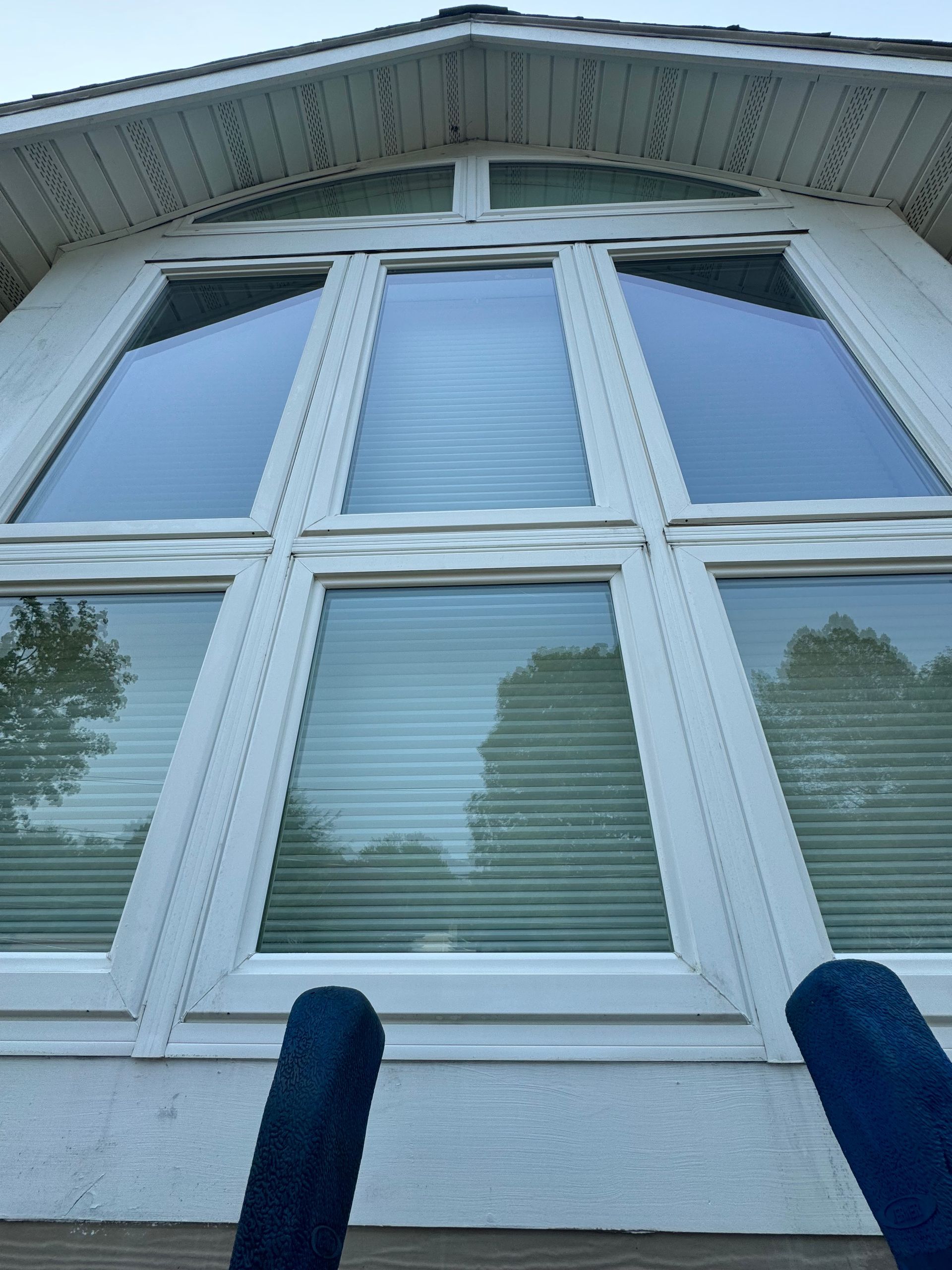 A white house with a lot of windows and blinds.