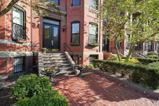 A large red brick building with stairs leading up to the front door.