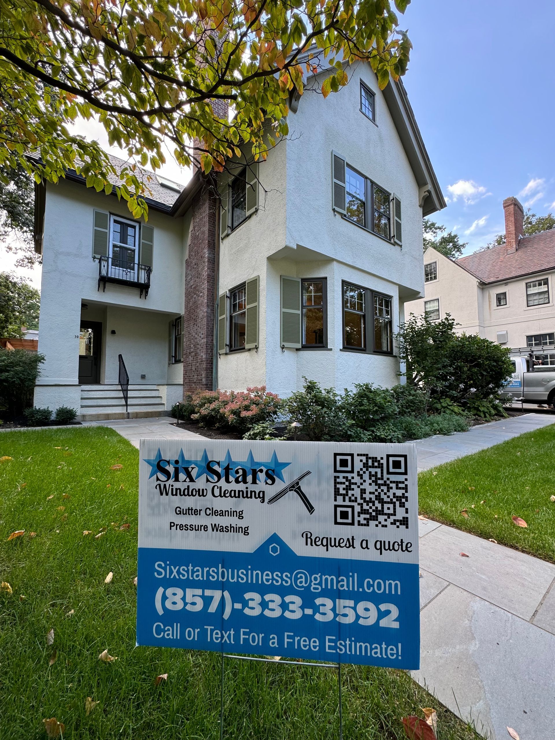 A white house with a blue sign in front of it.
