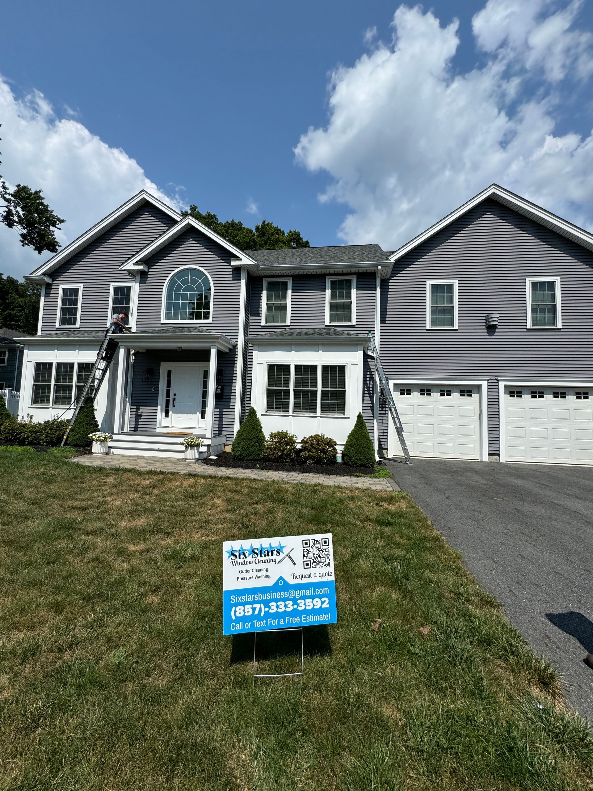 A large house with a for sale sign in front of it.
