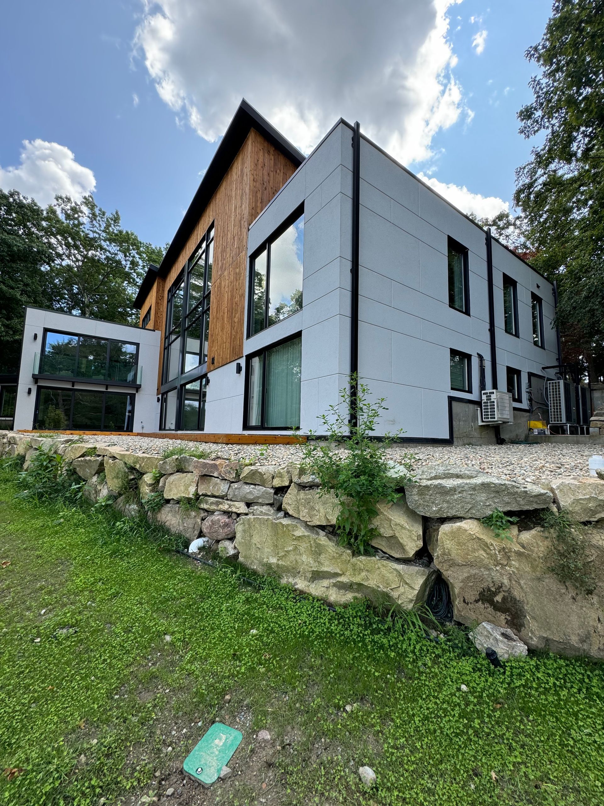 A large house with a lot of windows is sitting on top of a hill.