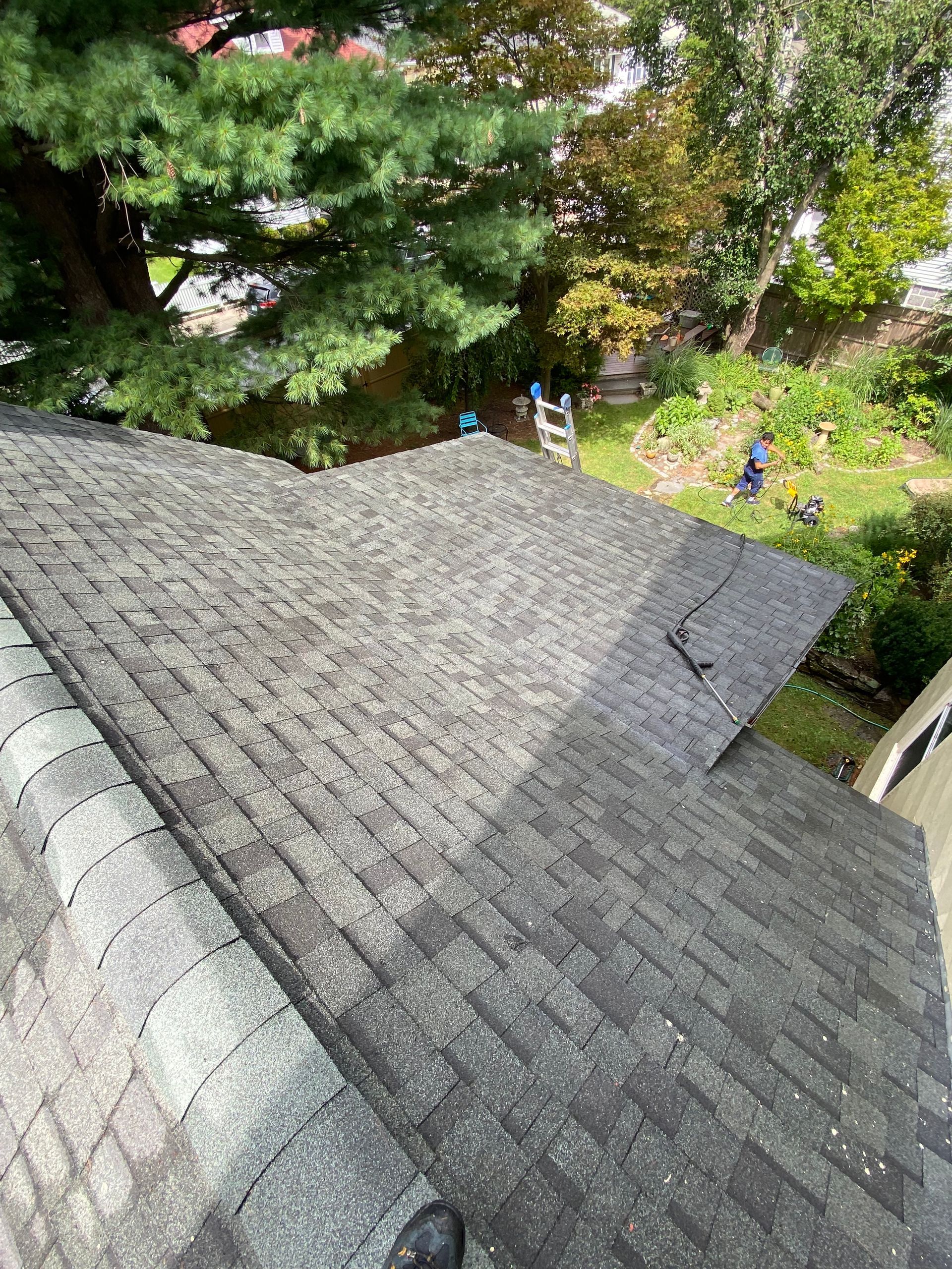 A person is standing on the roof of a house.