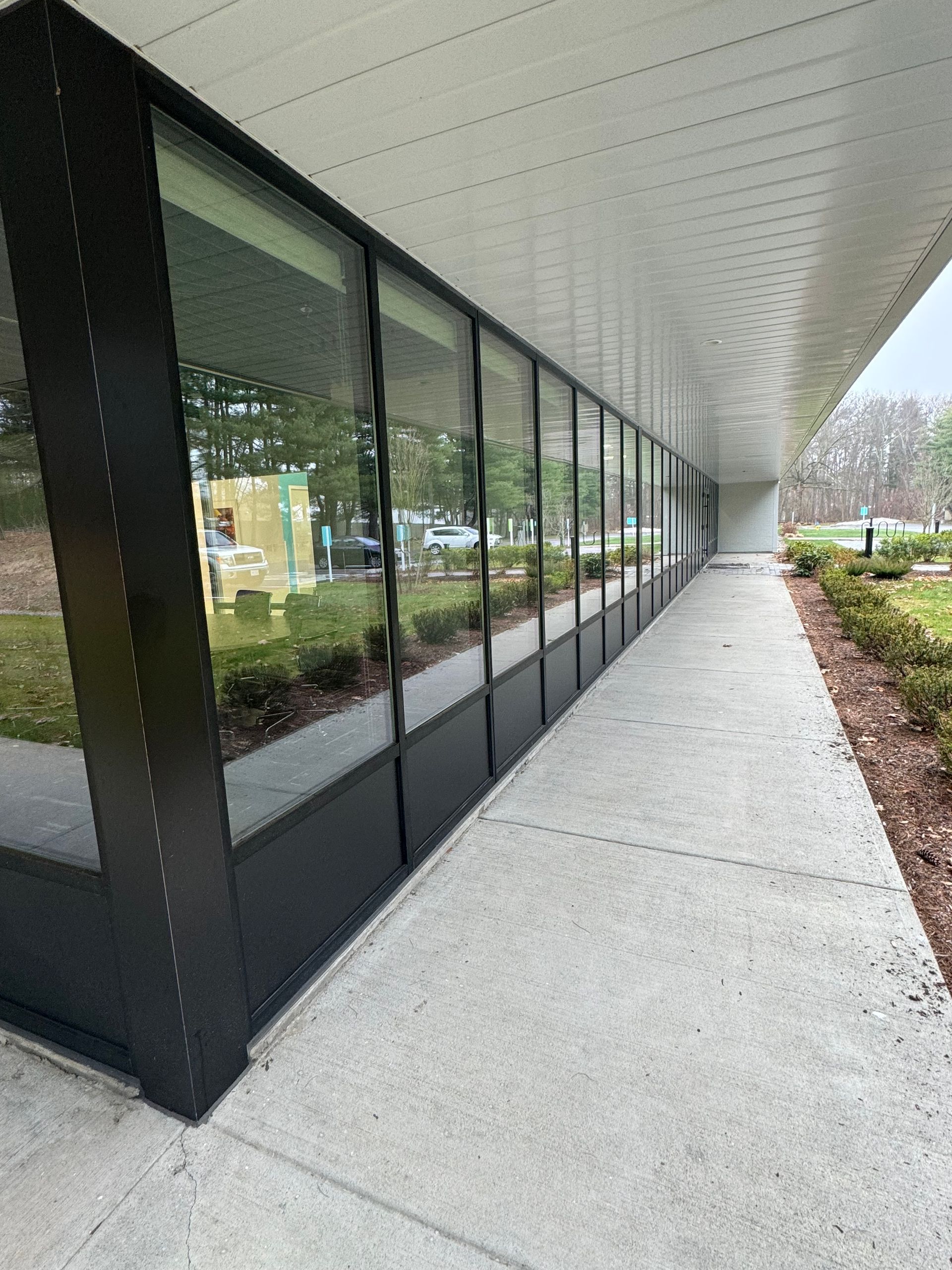 A long walkway leading to a building with a lot of windows.