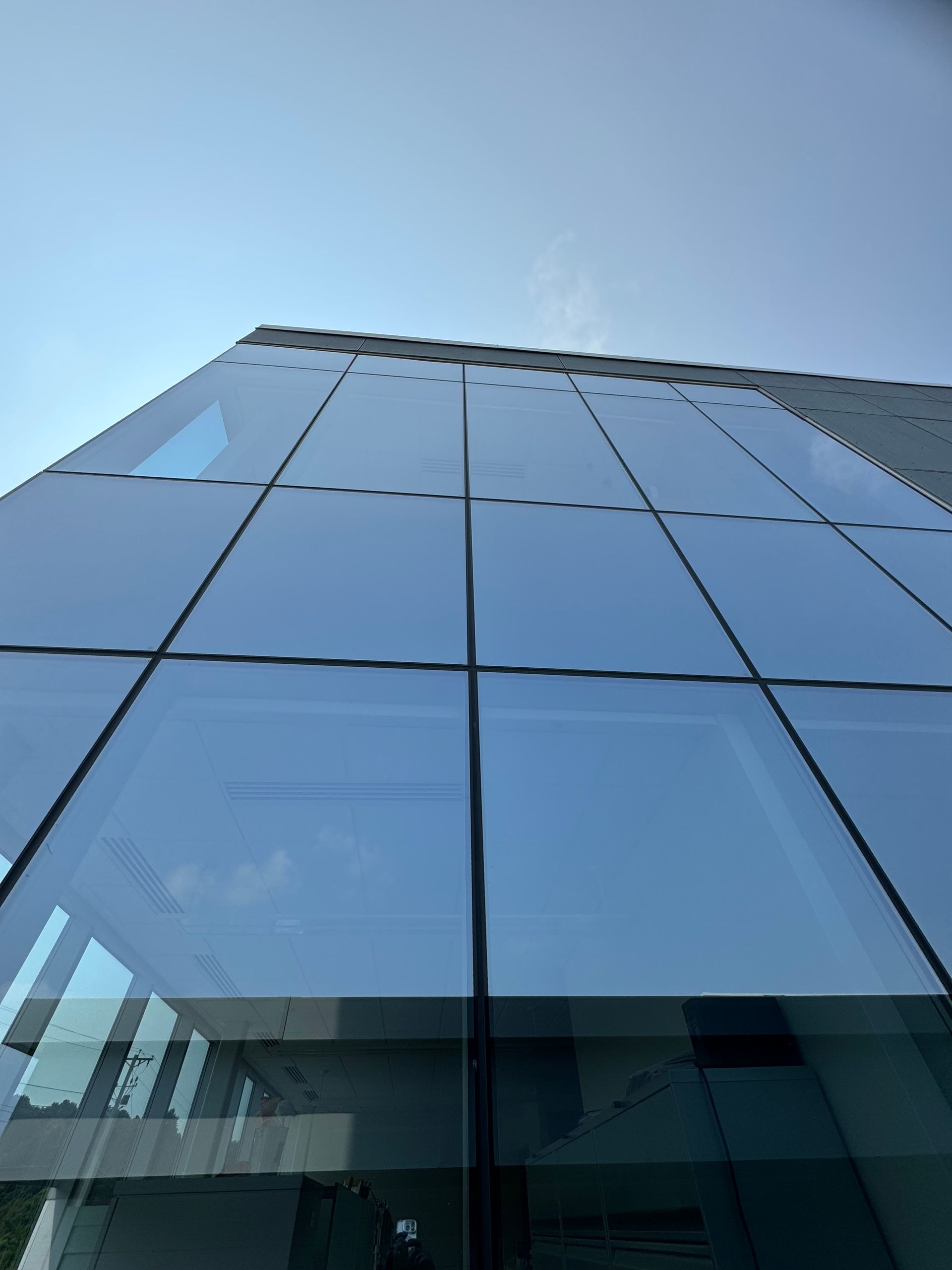 Looking up at a tall building with a blue sky in the background.