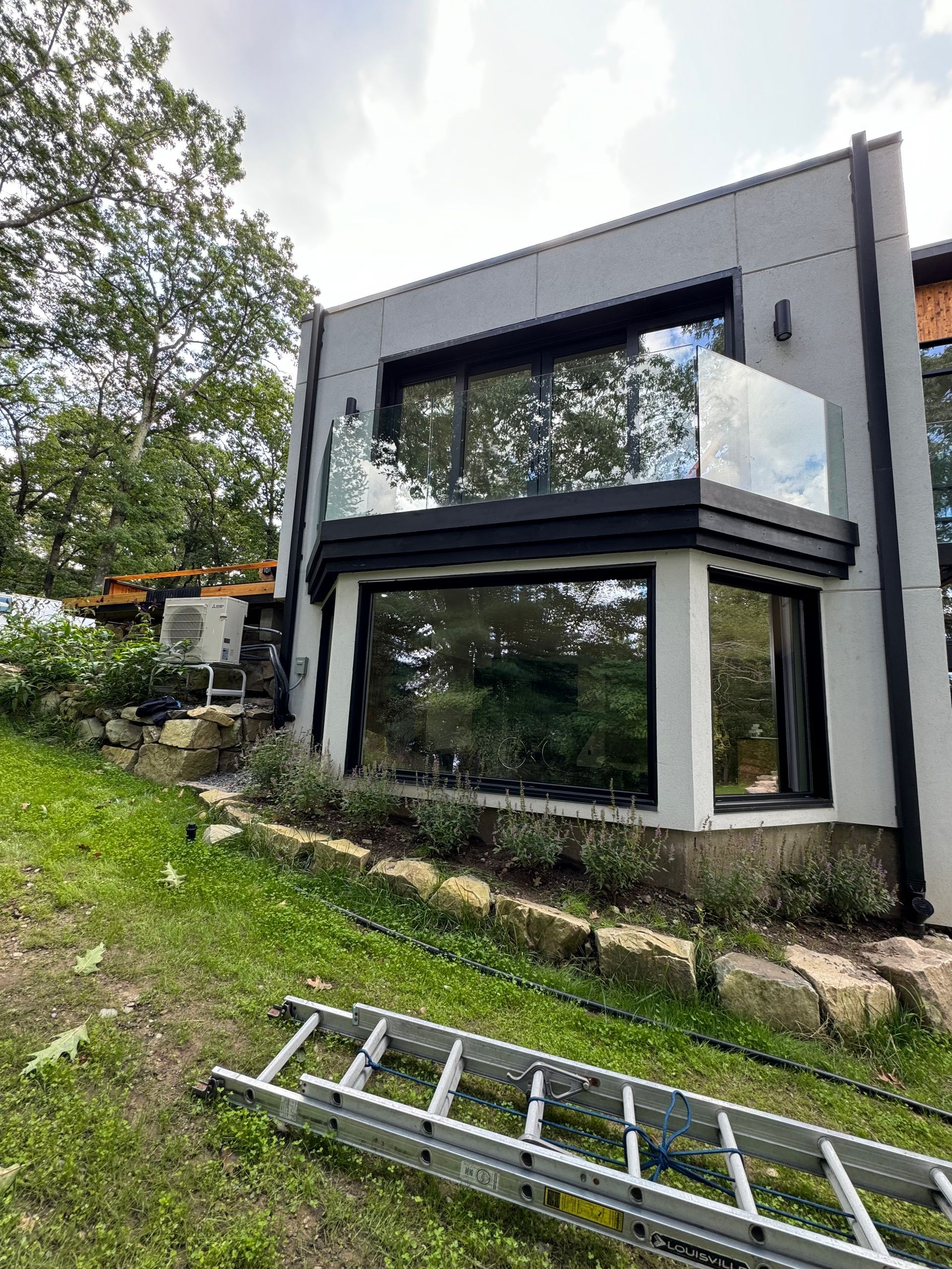 A ladder is sitting in front of a large house.