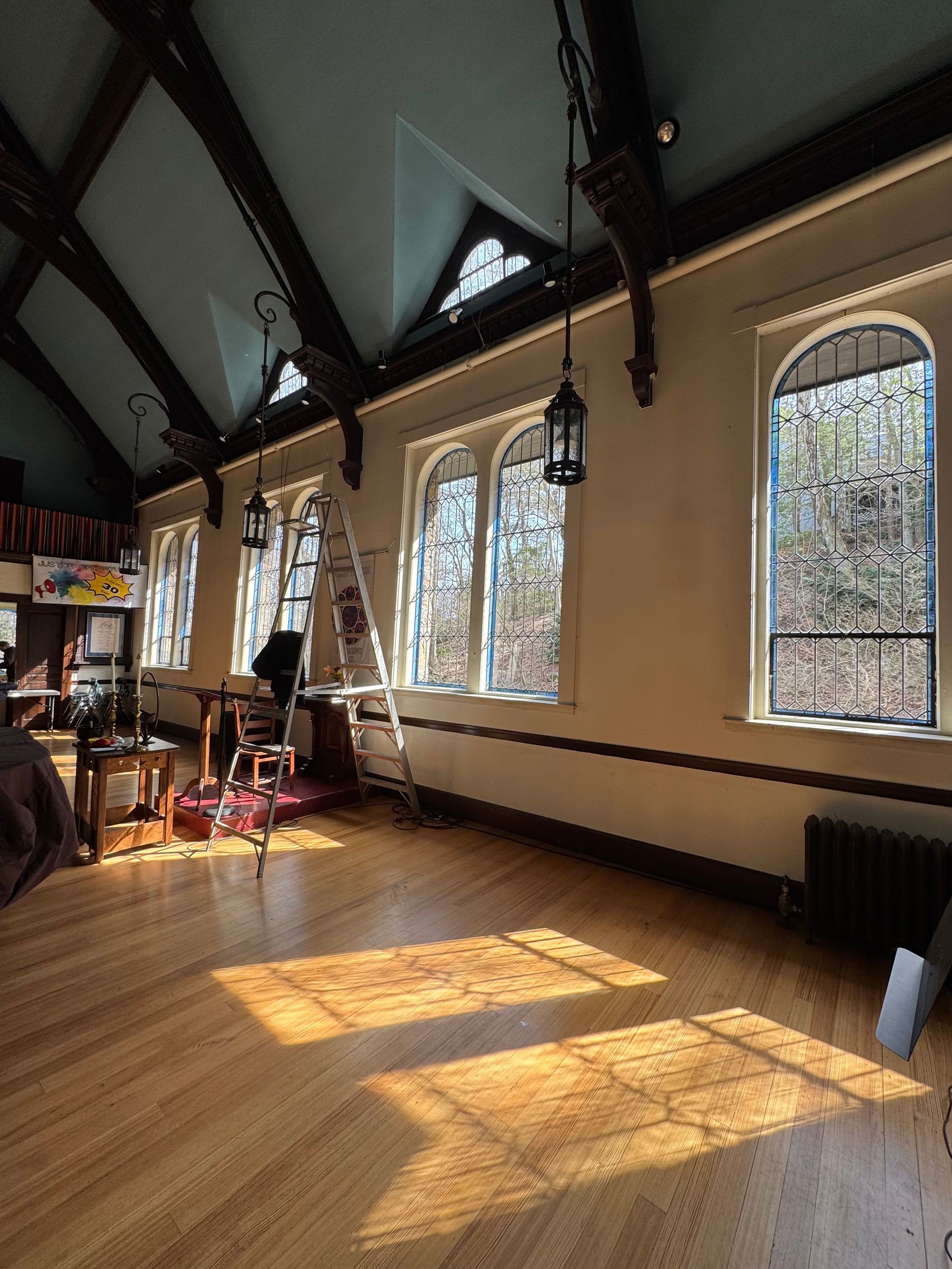 A large room with lots of windows and a wooden floor.