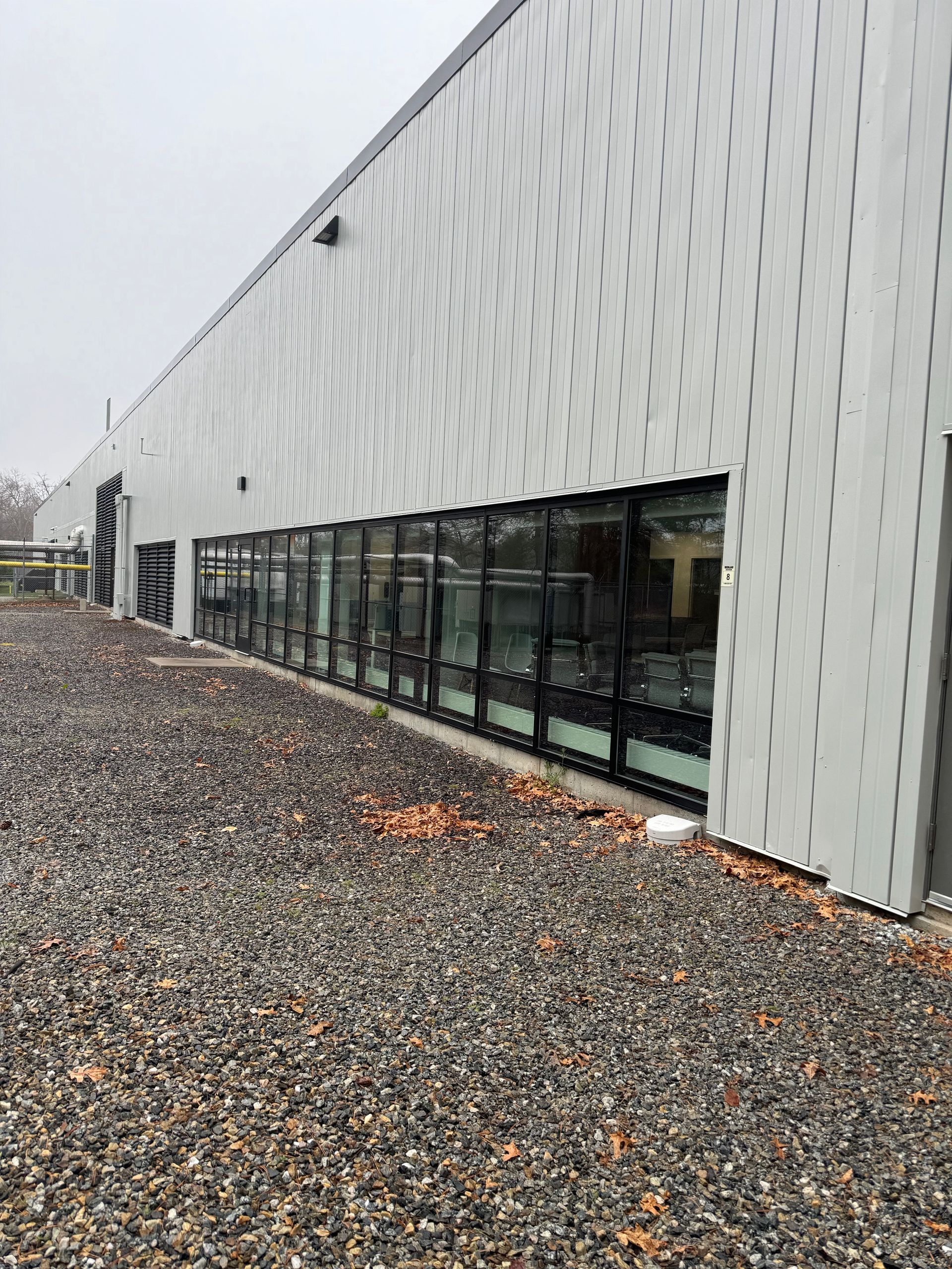 A large building with a lot of windows and gravel in front of it.