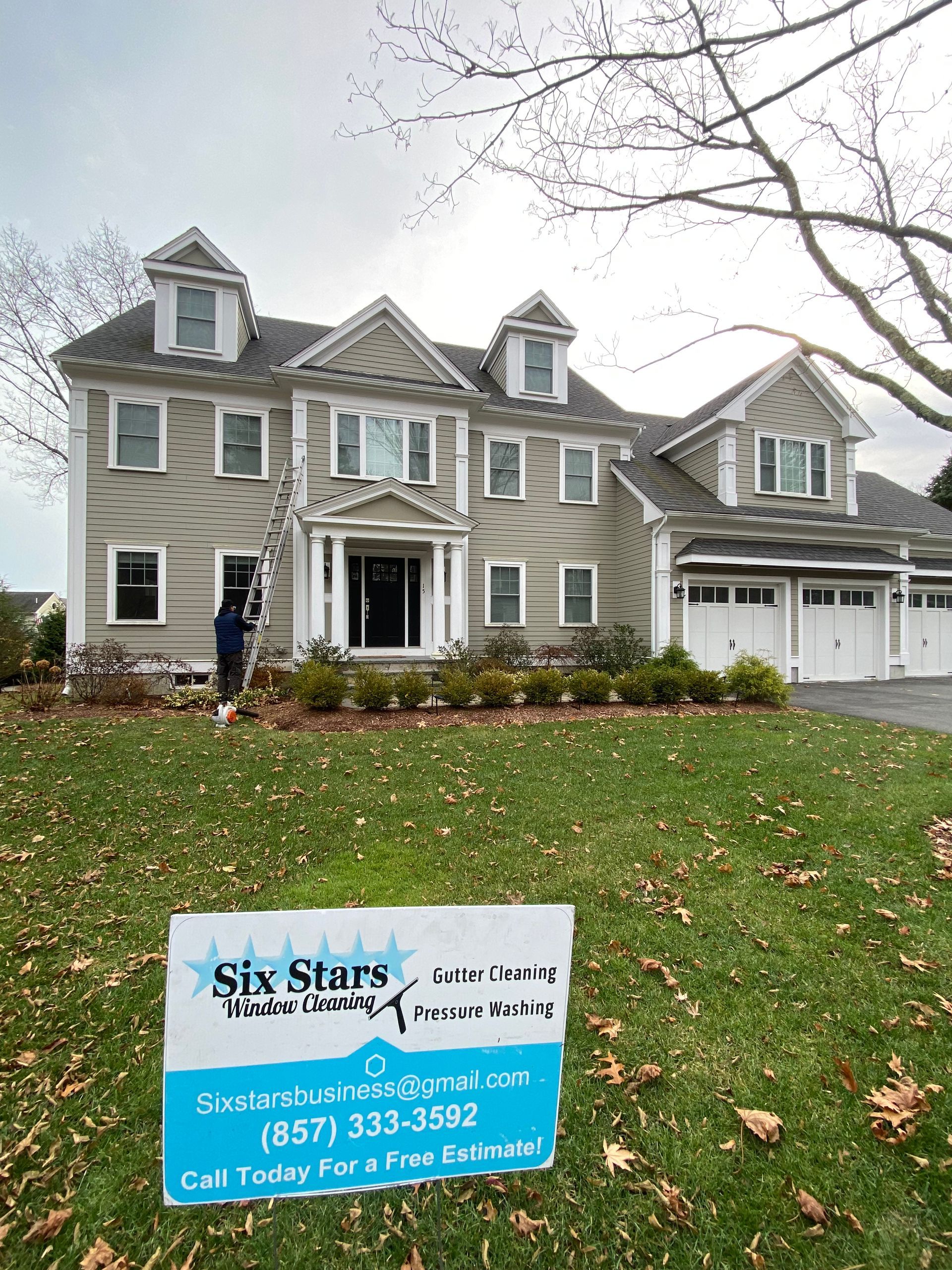 A large house with a sign in front of it.