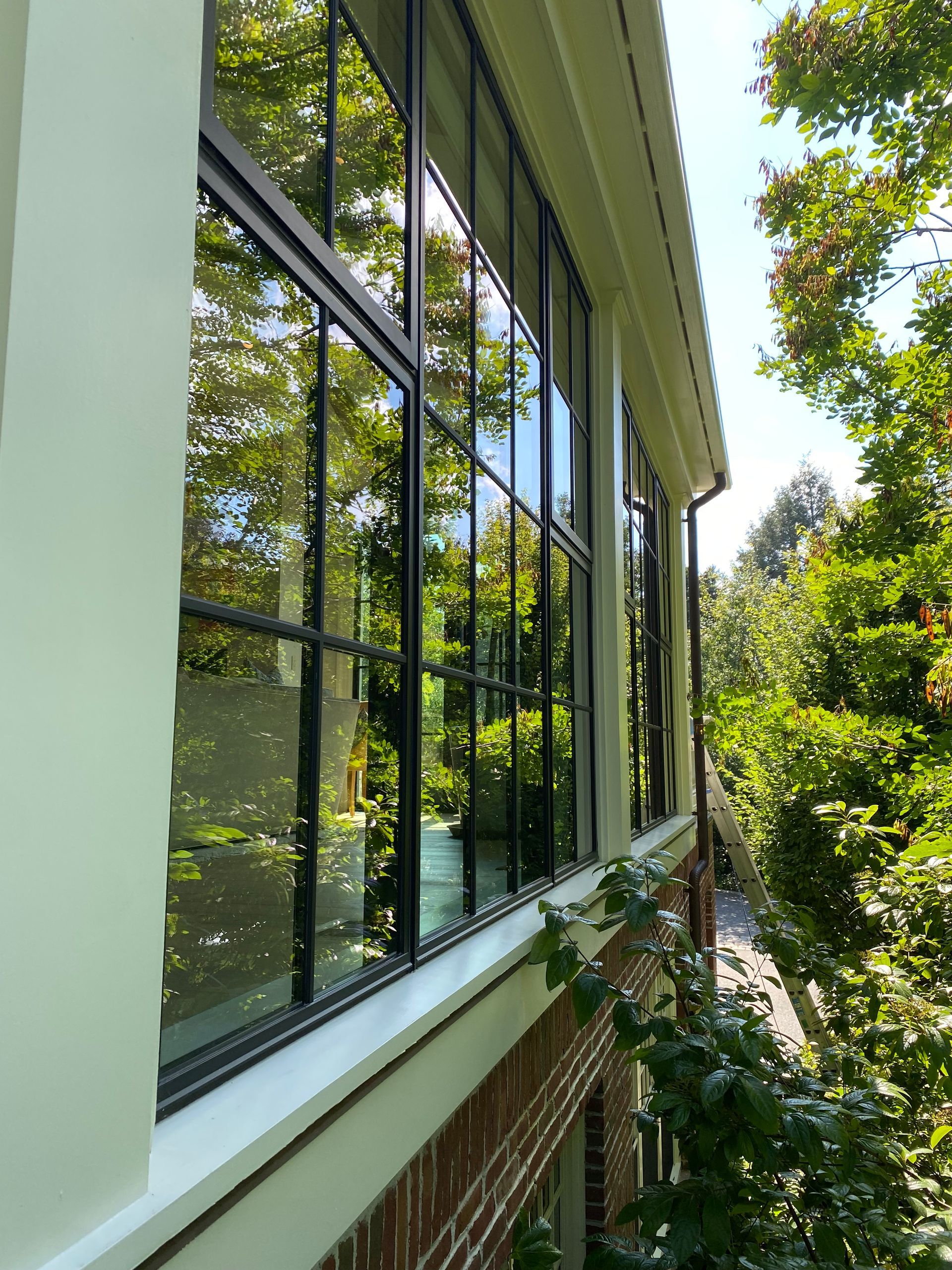 A house with a lot of windows and trees in the background.