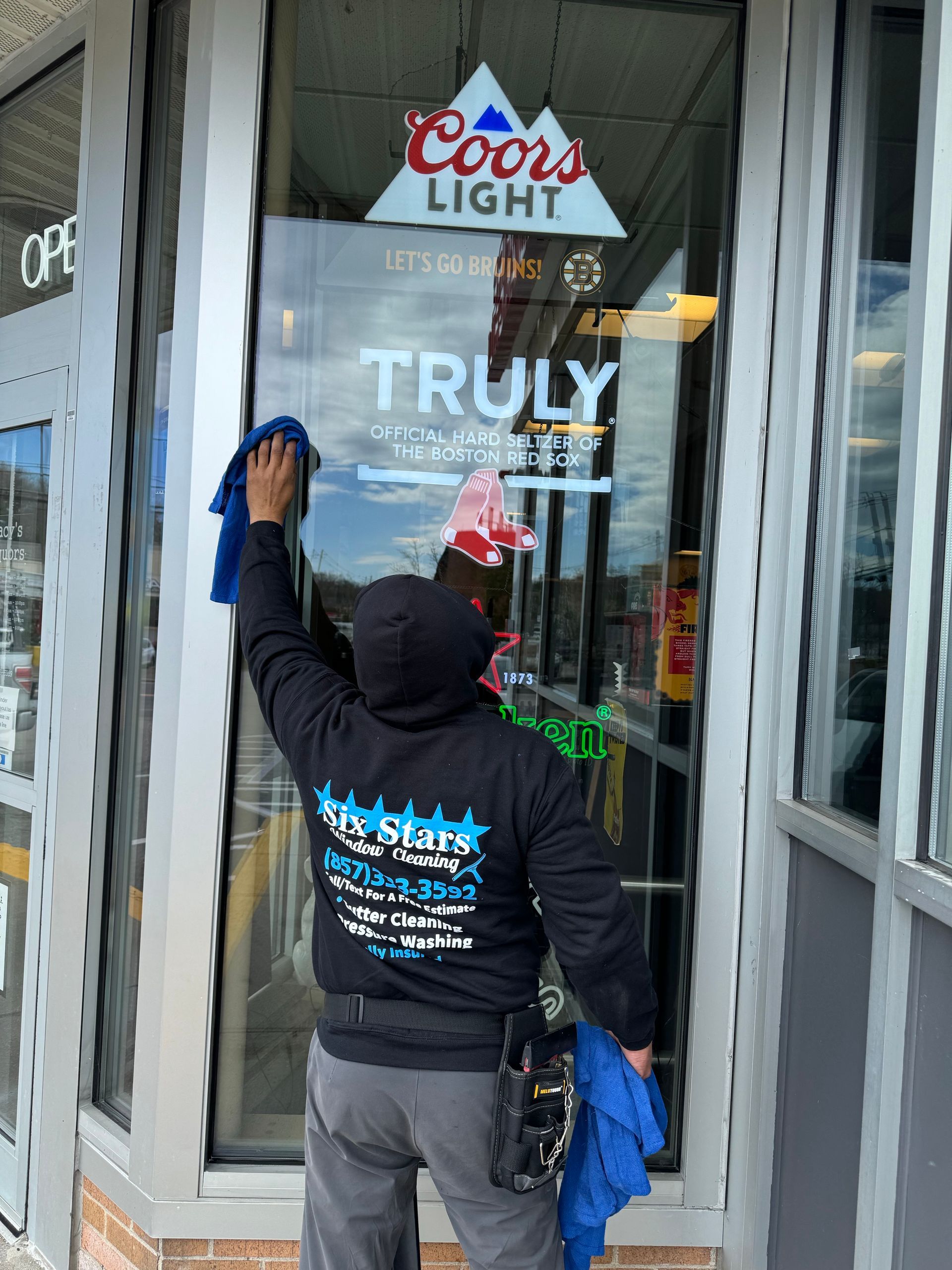 A man is cleaning a store window.