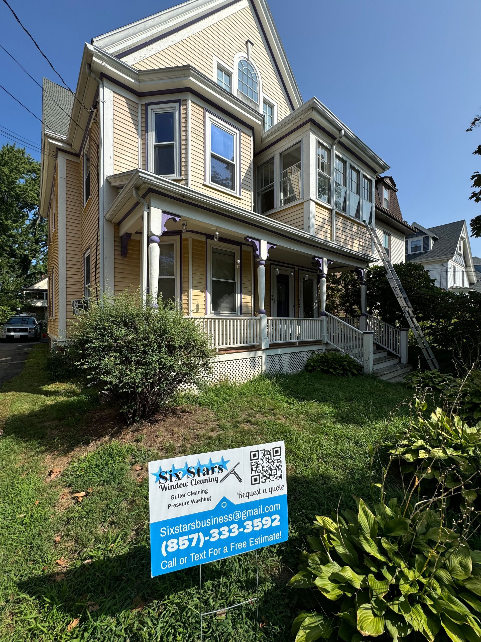 A large house with a for sale sign in front of it.