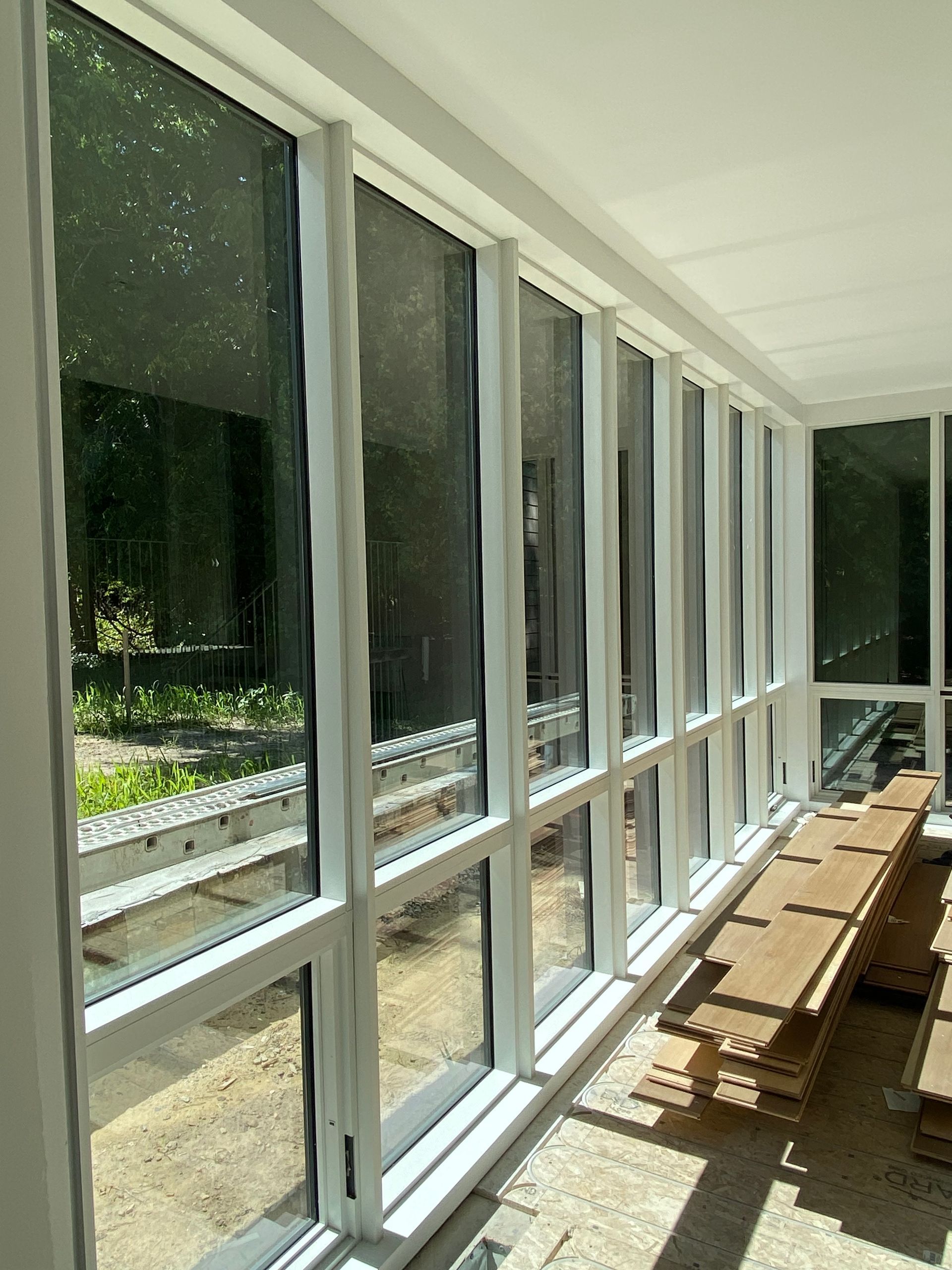 A room with a lot of windows and a wooden bench.