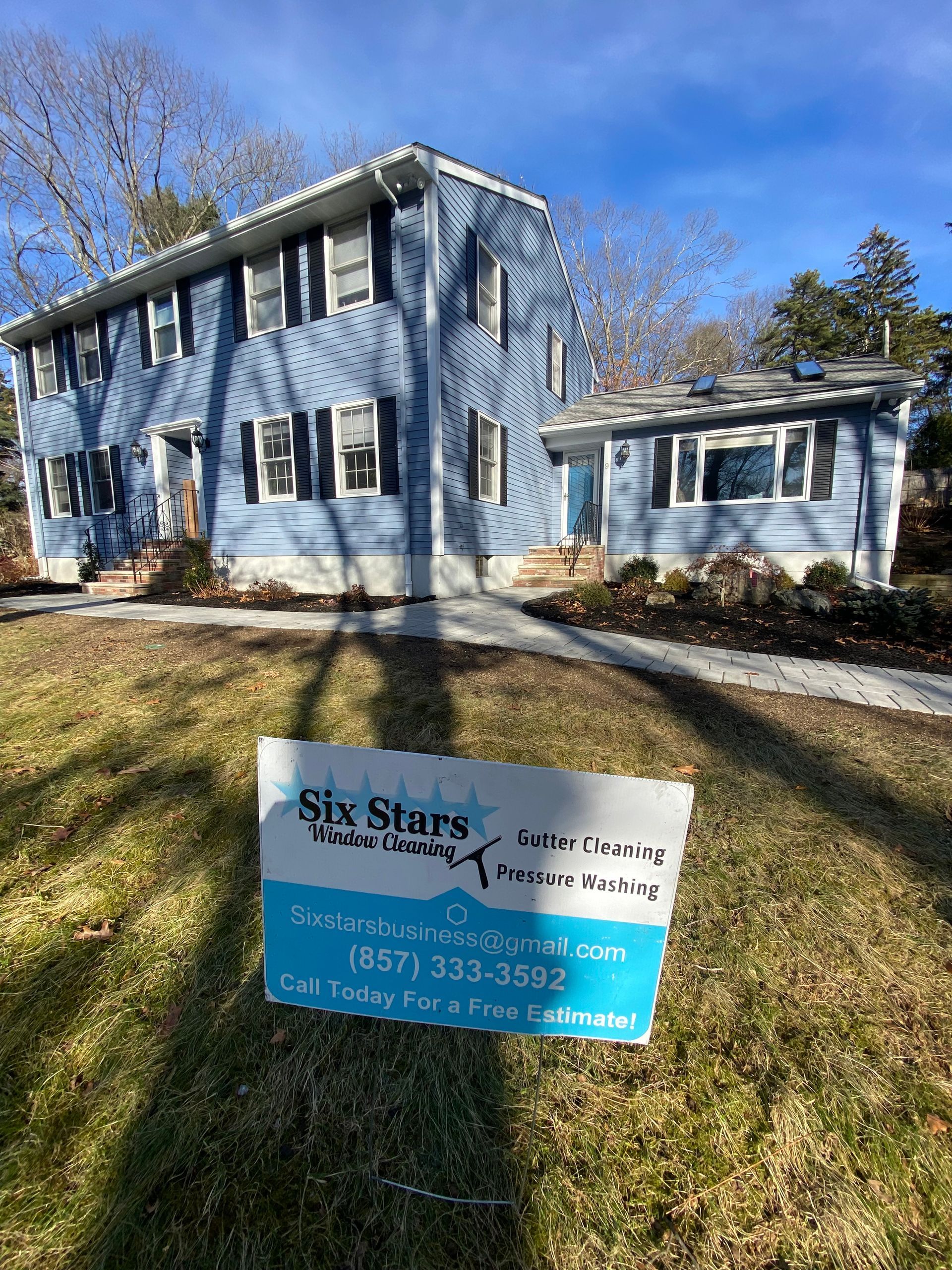 A blue house with a sign in front of it.