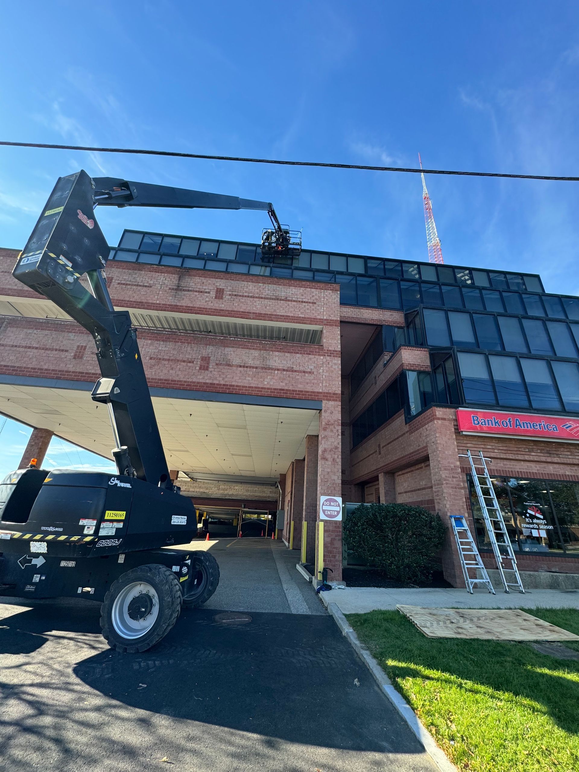 A crane is working on the roof of a building.