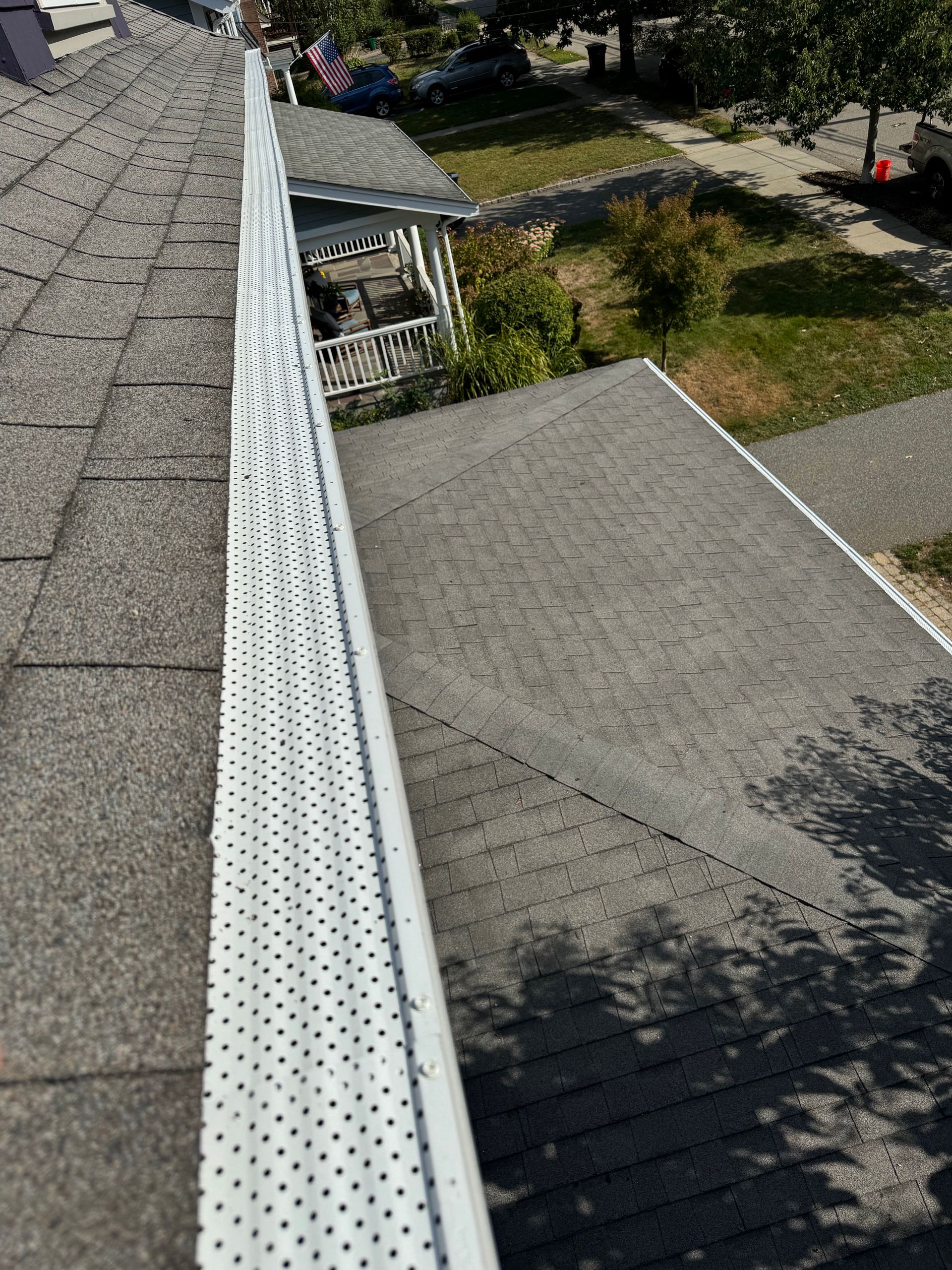 A gutter on the side of a house with a drain on the roof.