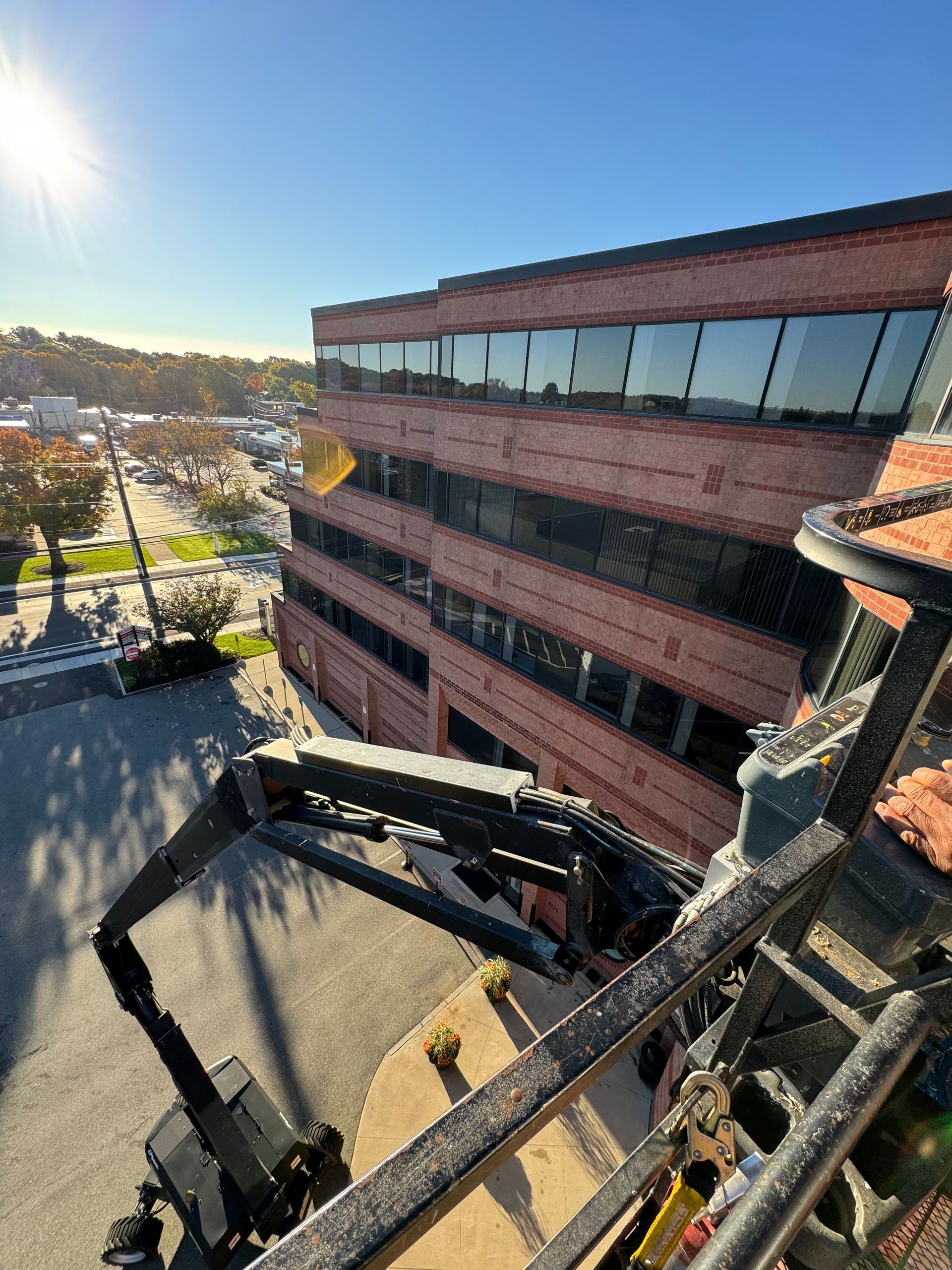 An aerial view of a large brick building with a crane in front of it.