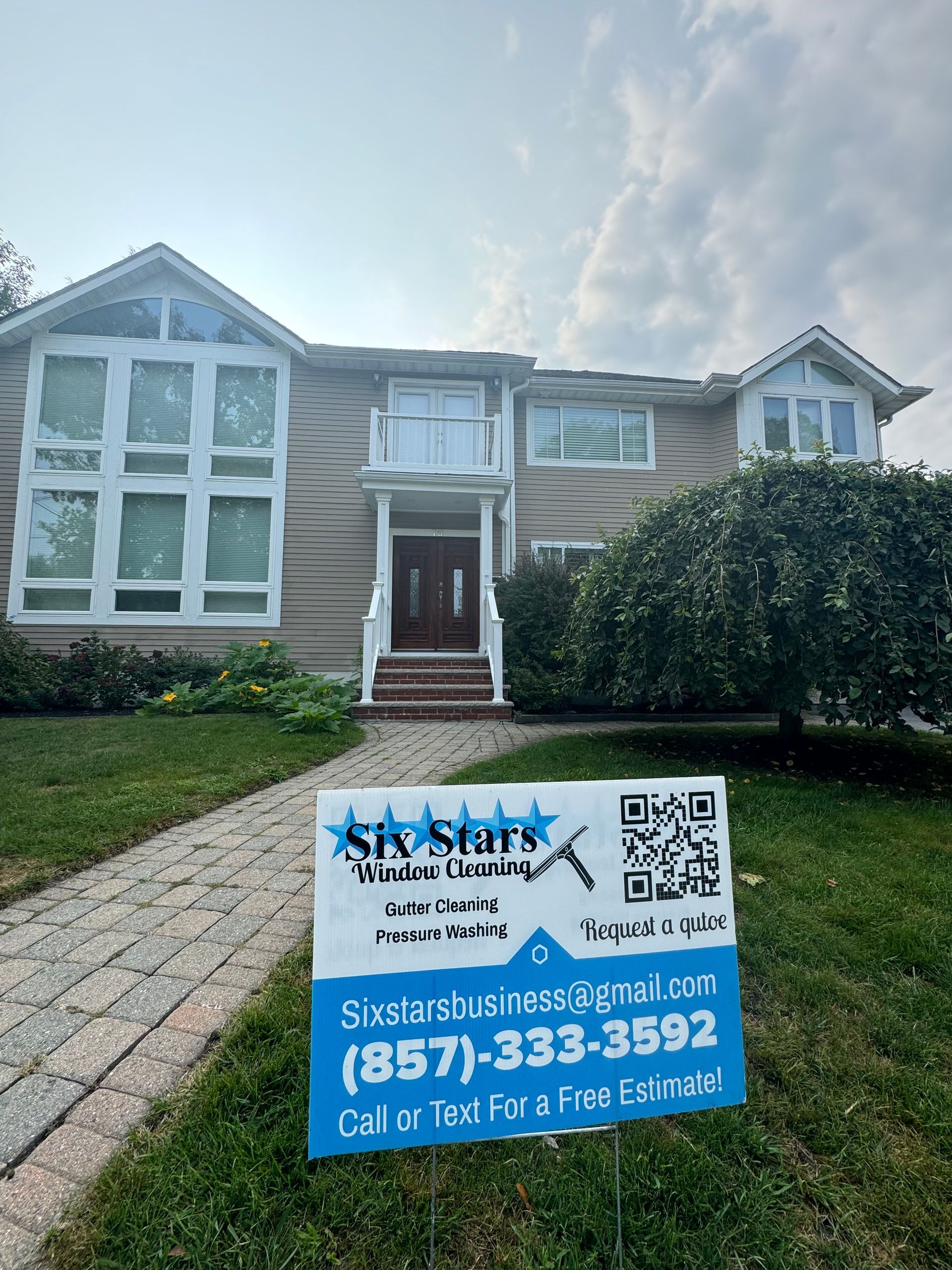 A house with a for sale sign in front of it.