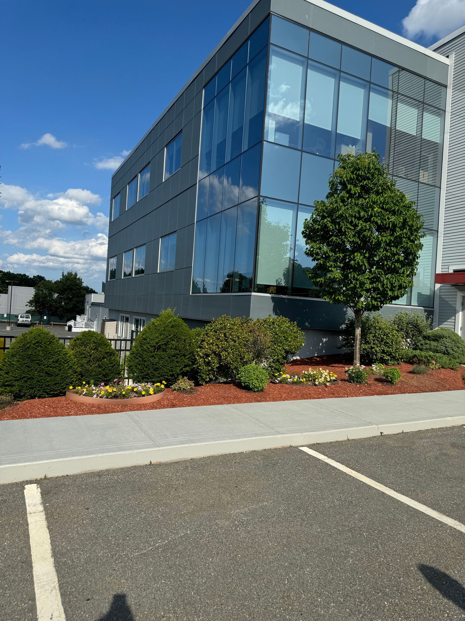 A large building with a lot of windows and a parking lot in front of it.
