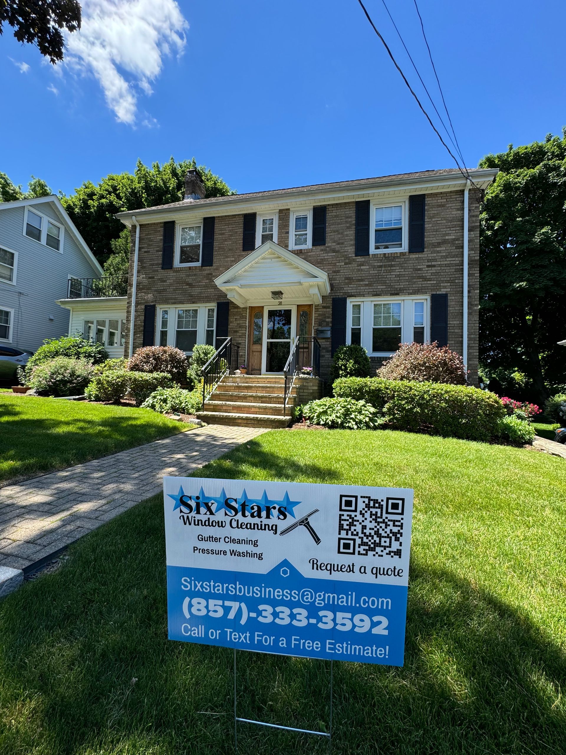 A house with a blue sign in front of it.