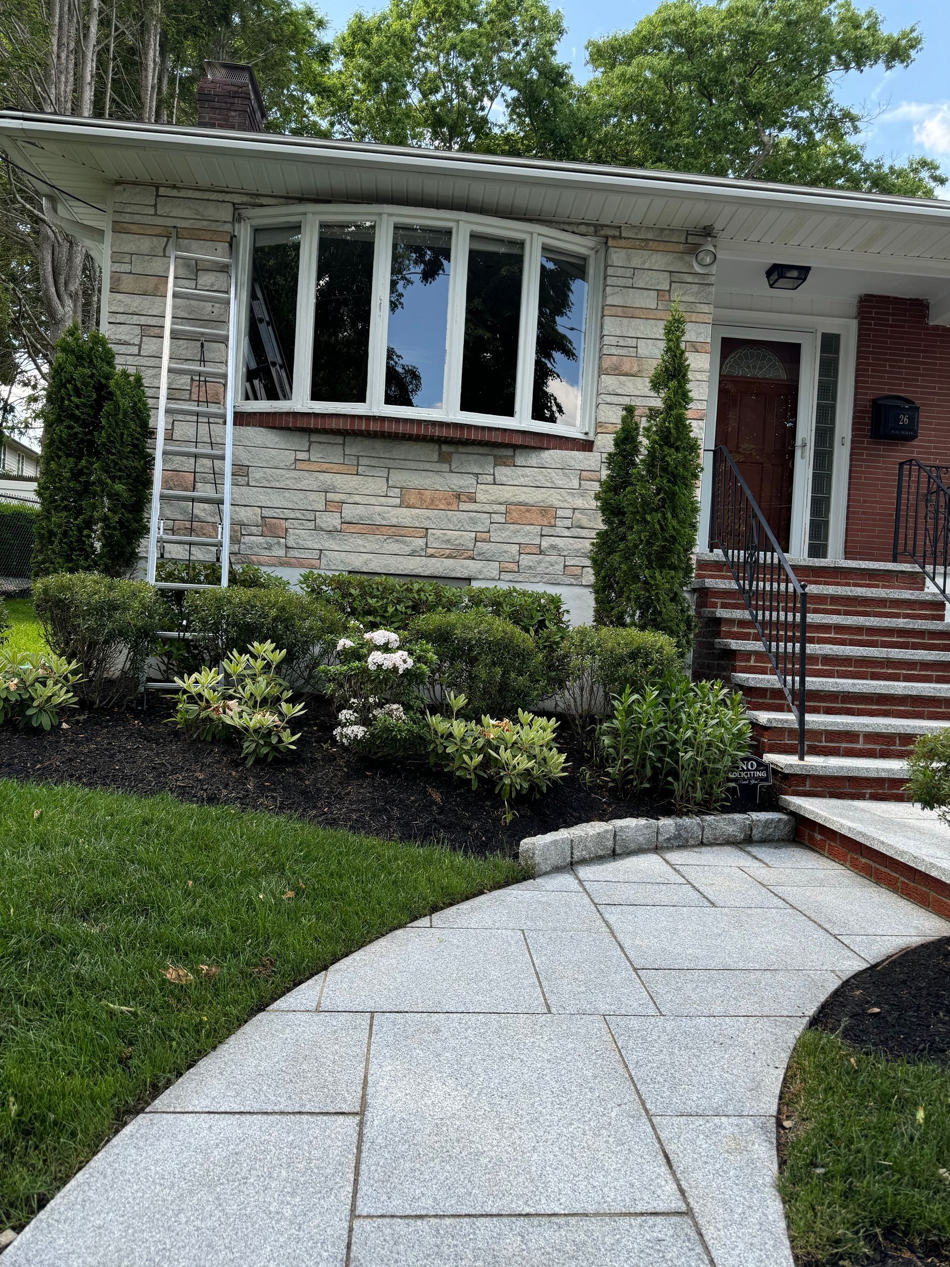 There is a walkway leading to the front of a house.
