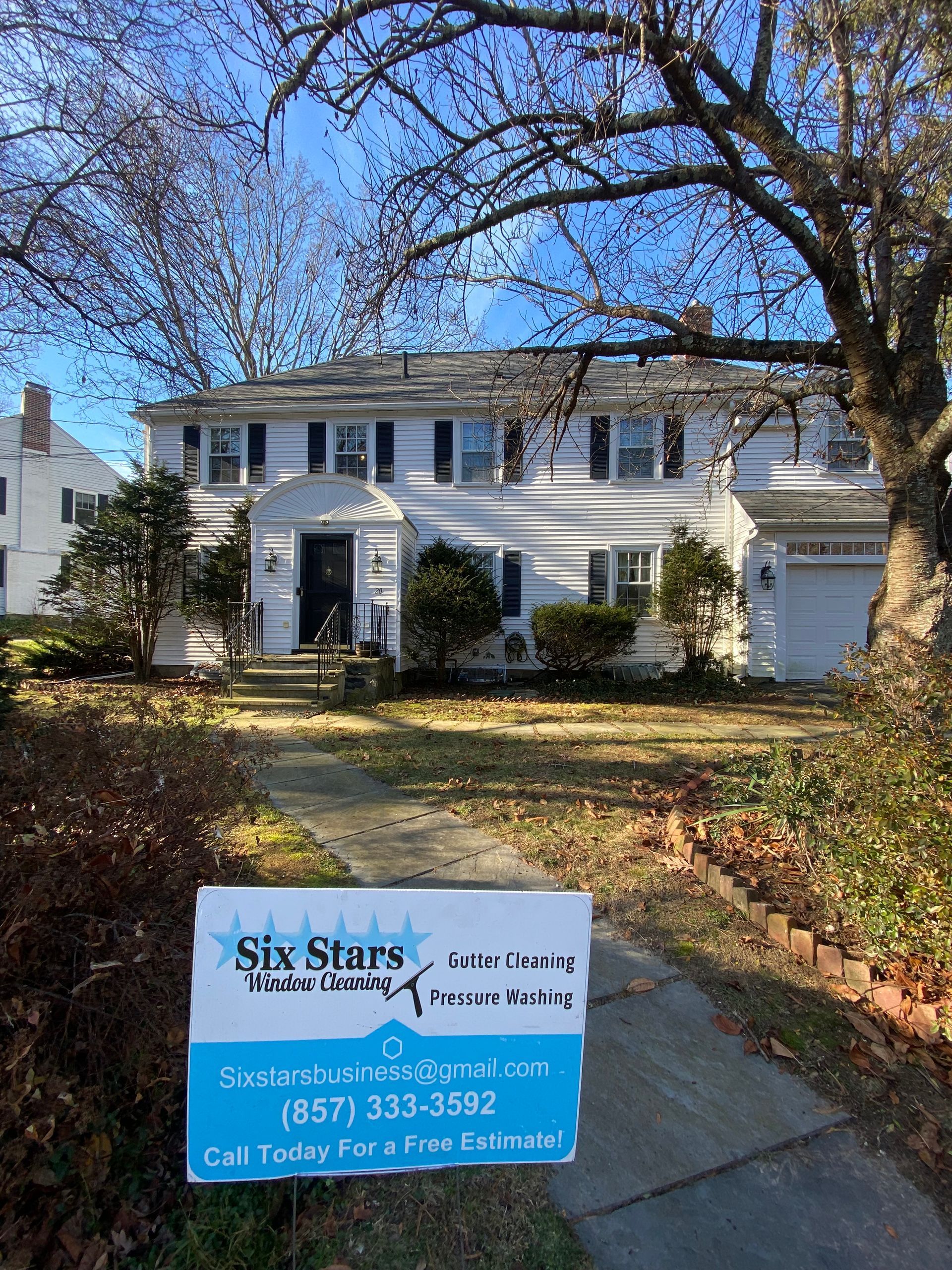 A white house with a for sale sign in front of it.