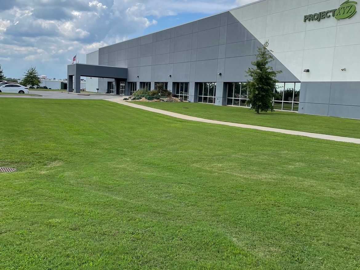 A large white building with a lawn in front of it