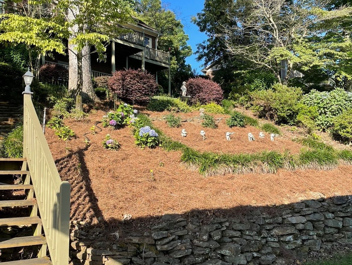 A house is sitting on top of a hill next to a stone wall