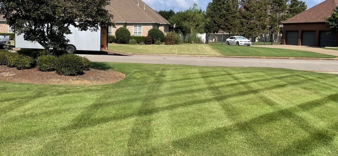 Lush green lawn is being mowed in front of a house