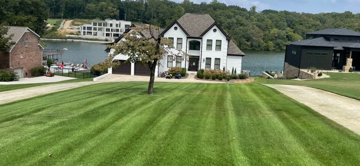 A large white house with a lush green lawn in front of it