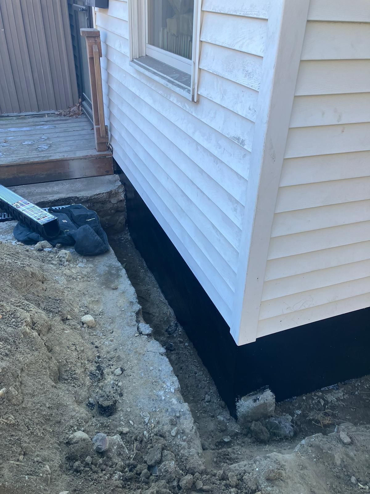 A white house with a black foundation is being built.