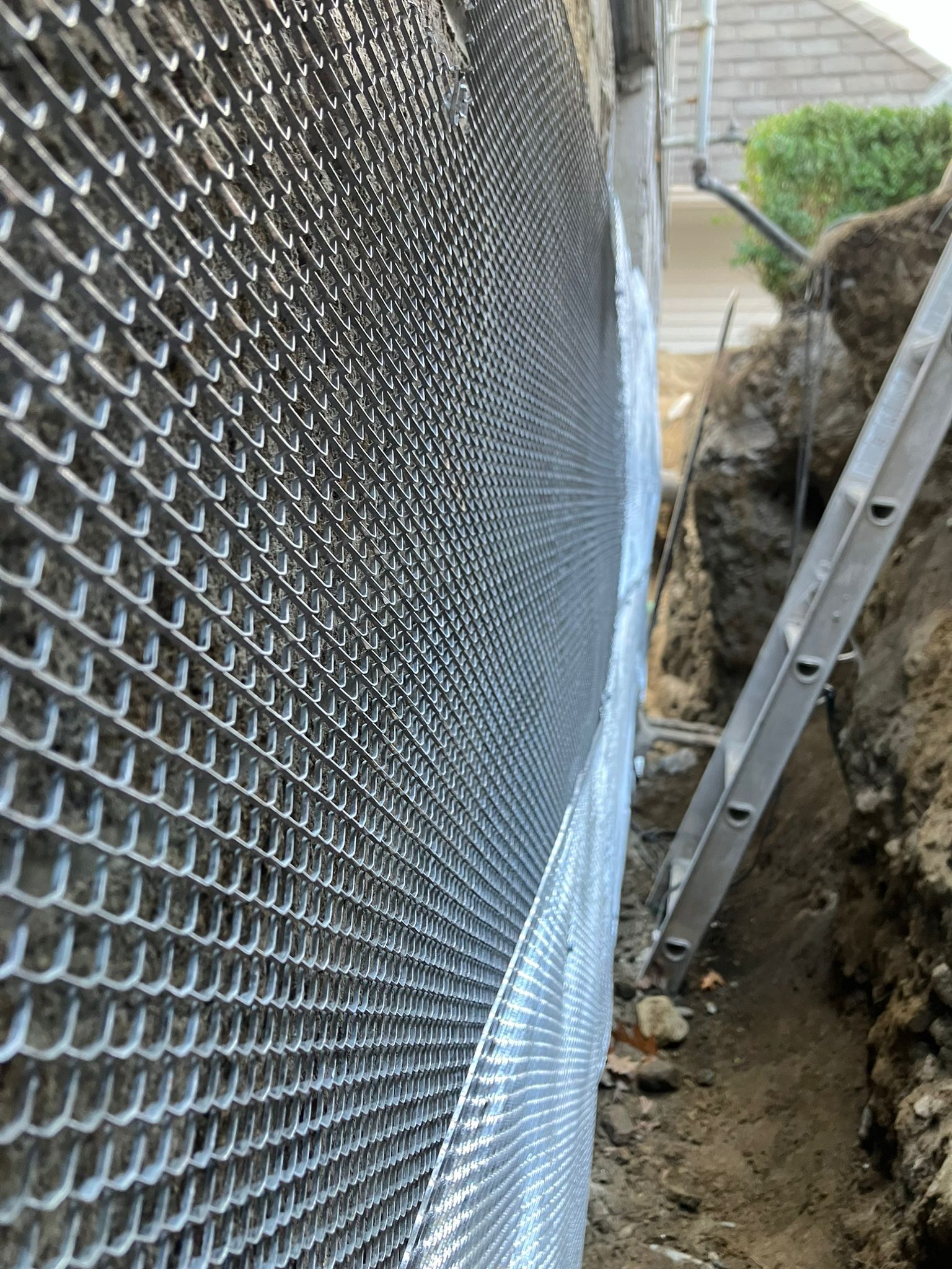 A ladder is sitting next to a chain link fence.