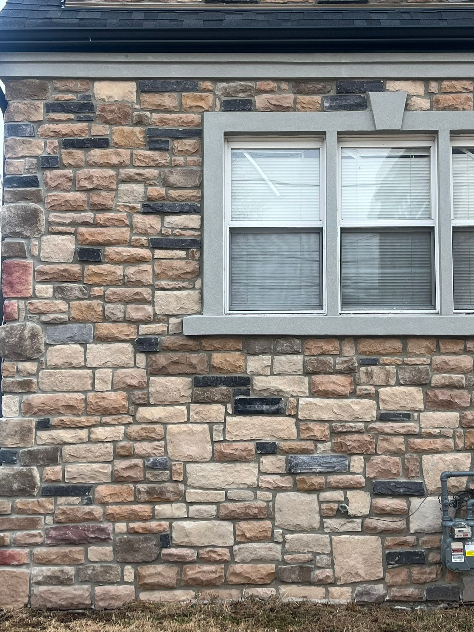 A brick wall with a window and blinds on it.