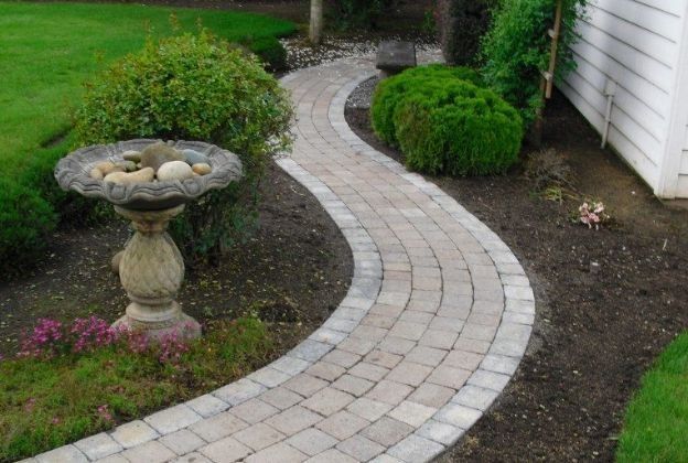 There is a bird bath on the side of the path.